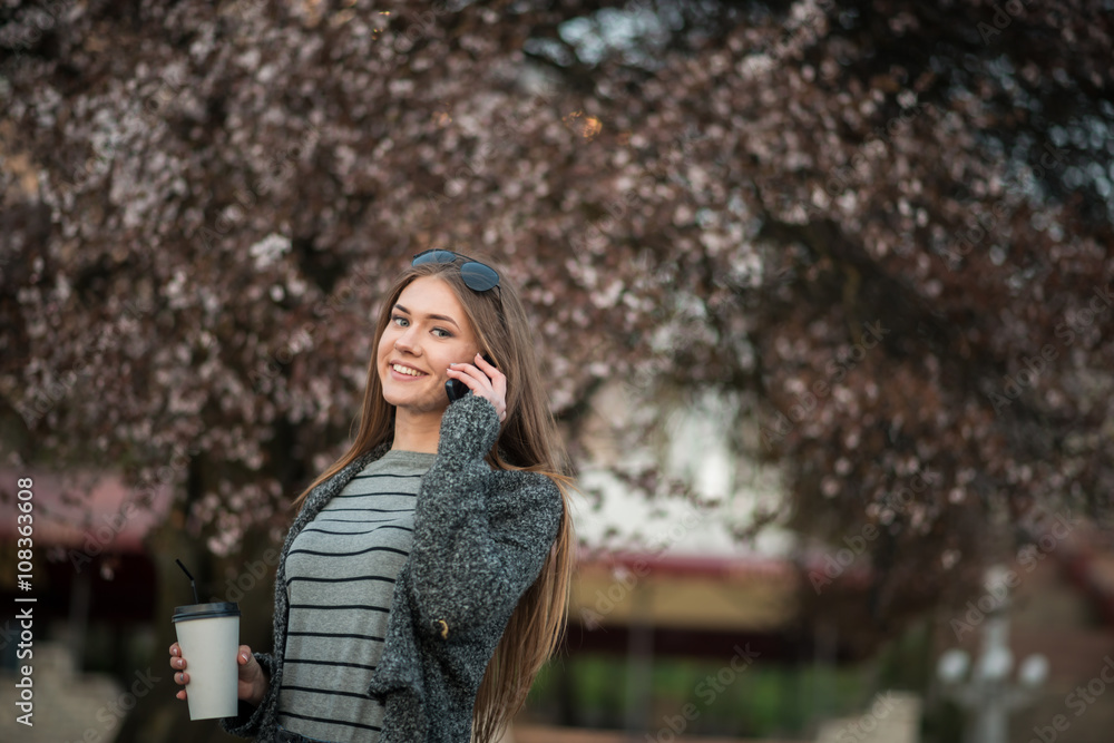 girl walking with coffee and phone
