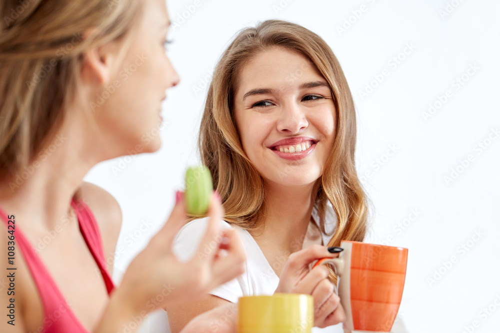happy young women drinking tea with sweets at home happy young women drinking tea with sweets at home