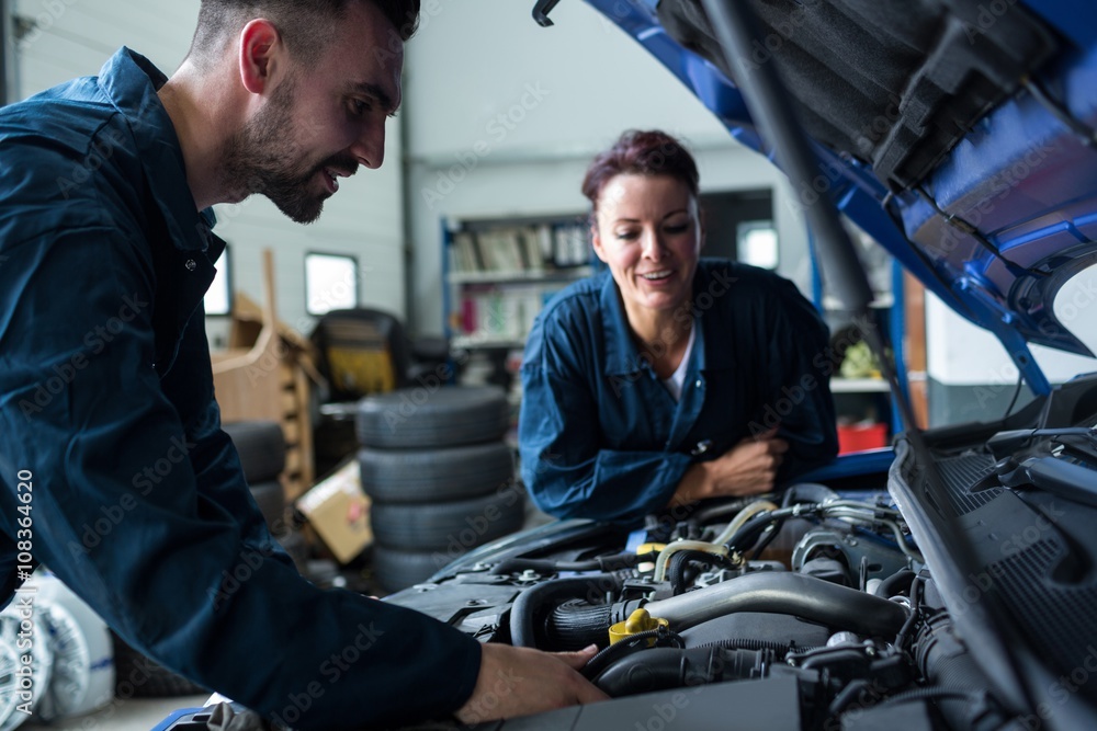 Team of mechanics examining car engine Team of mechanics examining car engine