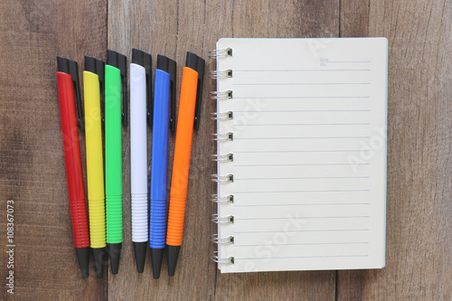 Photography Notebook and pen on old wood for the design background.
