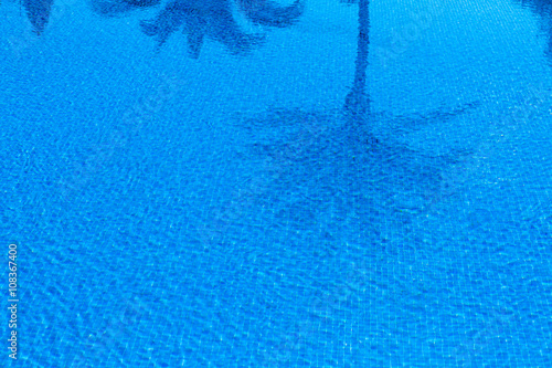 Swimming Pool in Holiday Hotel with reflections of palm trees