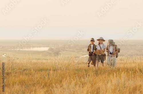 Group of kids travelers read a map at sunset © Alexandr Vasilyev