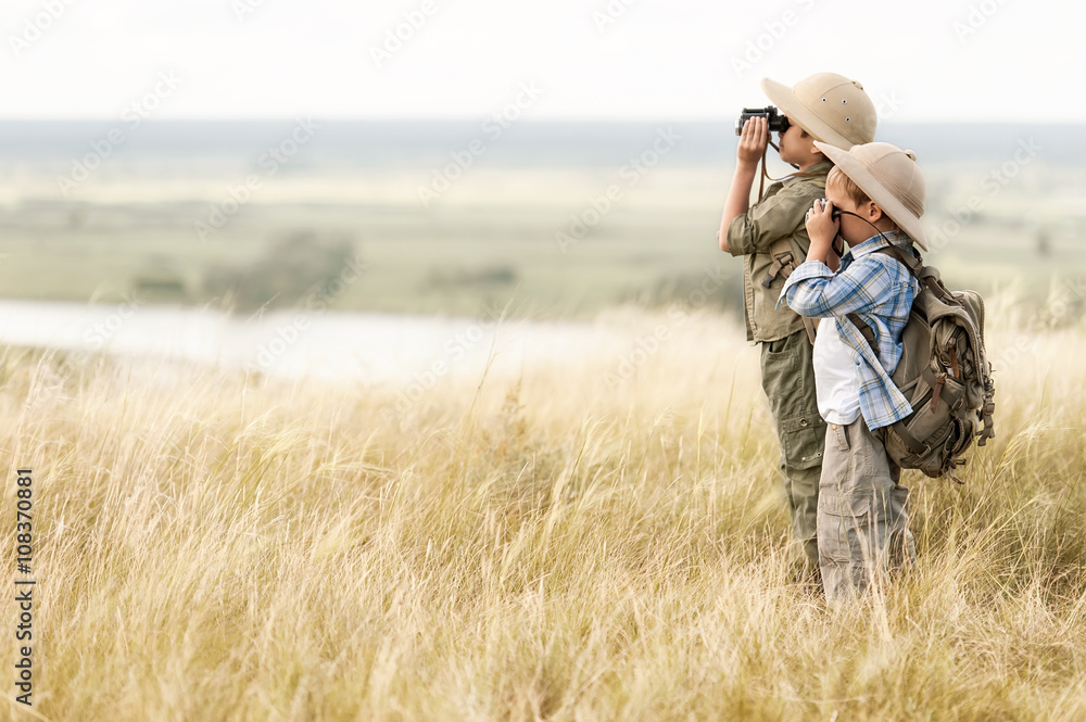 Children with tourists looking through binoculars into the distance on the precipice