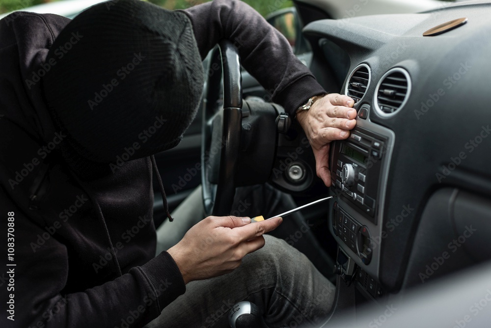Car thief head trying to steal car radio