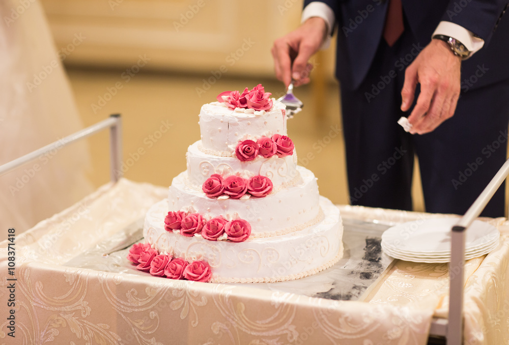 bride and a groom is cutting their wedding cake