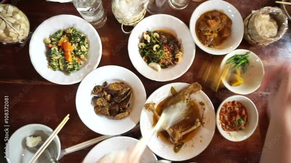 Point of view of hand eating variety traditional Thai food cuisine from top. sticky rice, curry and paste POV Point of view of hand eating variety traditional Thai food cuisine from top. sticky rice, curry and paste POV