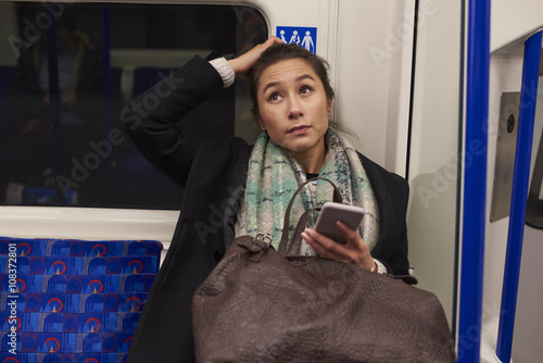 Woman Sitting In Metro Carriage Looking At Text Message photo