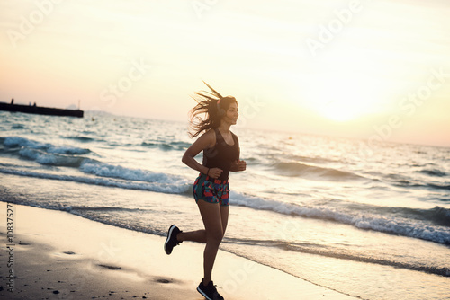 Young woman running at beach.