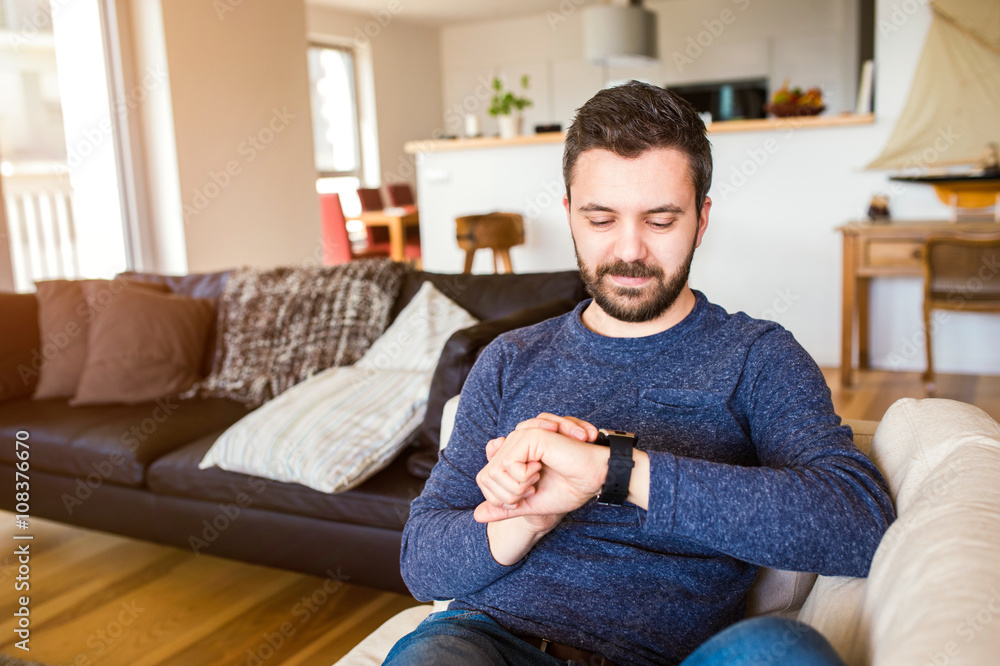 Man working from home using smart watch, living room