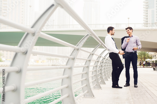 Canvas Print Two handsome businessmen talking at street.