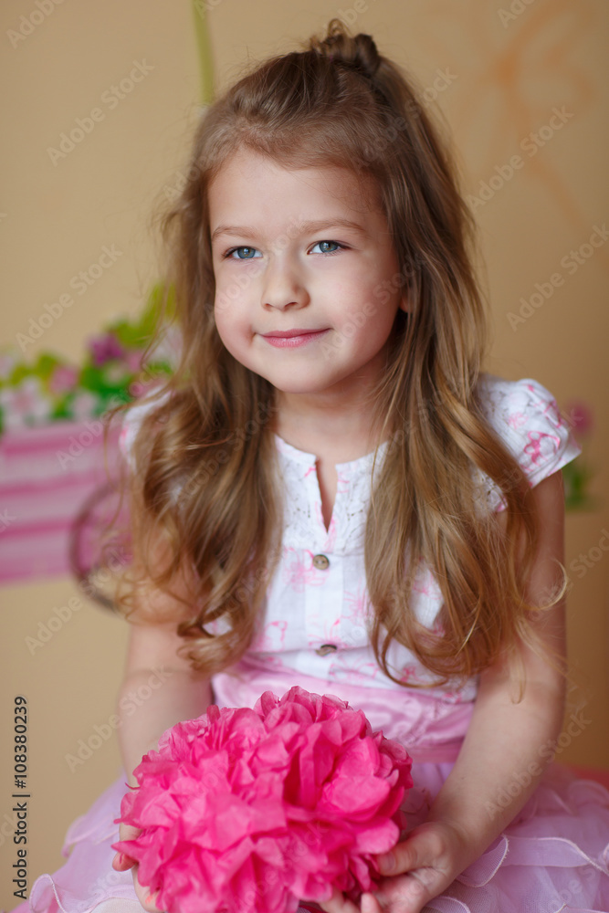Beautiful little girl smiling and holding a paper flower Beautiful little girl smiling and holding a paper flower