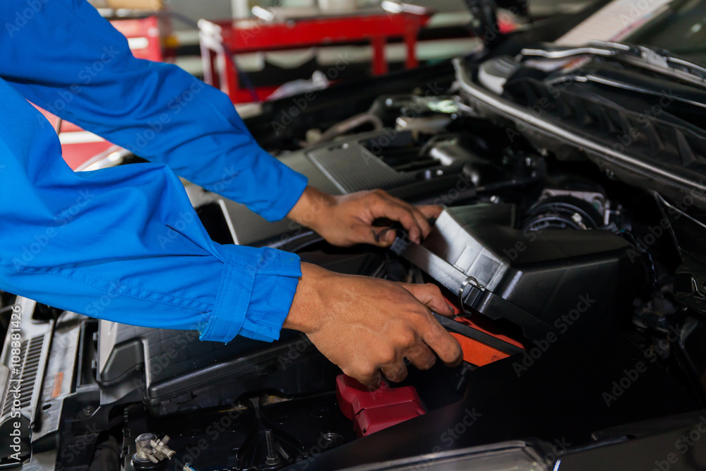 Mechanic checking and fixing a broken car in car service garage Mechanic checking and fixing a broken car in car service garage