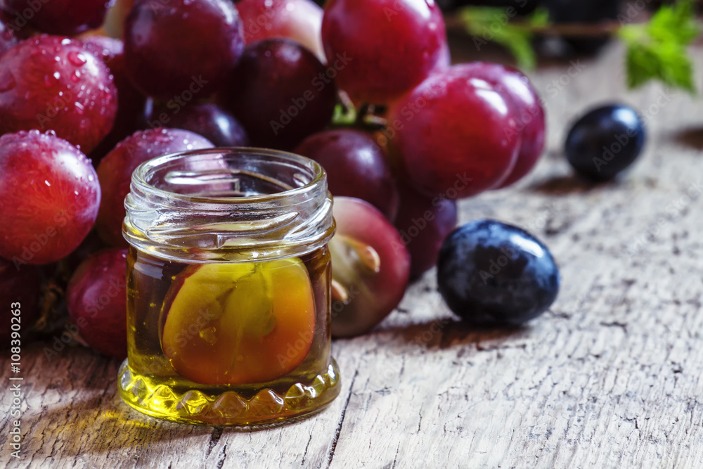 Essential oil of grape seeds and a fresh bunch of grapes, vintag Essential oil of grape seeds and a fresh bunch of grapes, vintag
