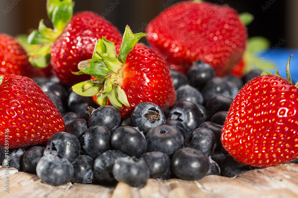Plate full of fresh blueberries and strawberries Plate full of fresh blueberries and strawberries