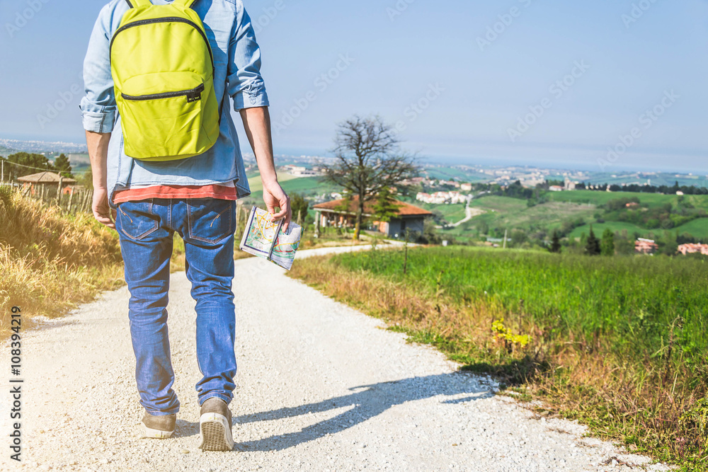 Closeup of a caucasian man with his backpack and map, walking alone, on travel - lifestyle,people,outdoor and Holiday concept