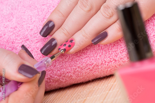 Manicure - Beauty treatment photo of nice manicured woman fingernails. Very nice feminine nail art with nice pink and purple nail polish.