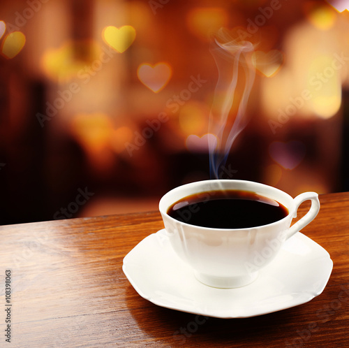 Cup of coffee on table on blured cafe background