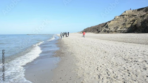 Beach and cliff between villages Ahrenshoop and Wustrow (Mecklenburg-Vorpommern, Germany). People walking along the beach 