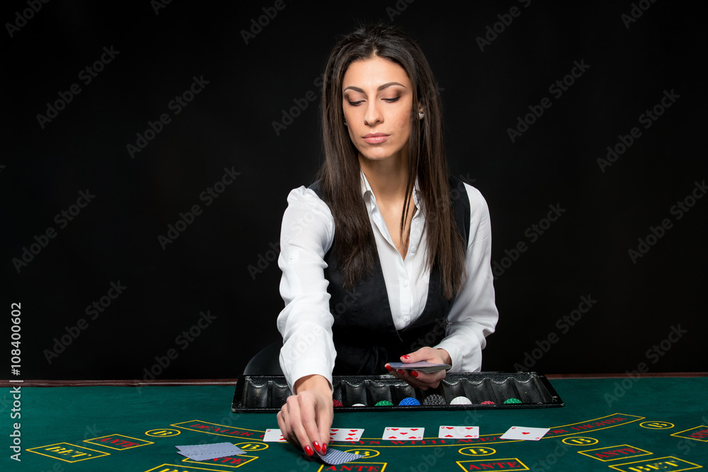 The beautiful girl, dealer, behind a table for poker The beautiful girl, dealer, behind a table for poker