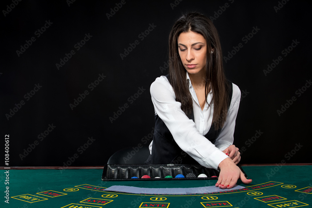 The beautiful girl, dealer, behind a table for poker The beautiful girl, dealer, behind a table for poker