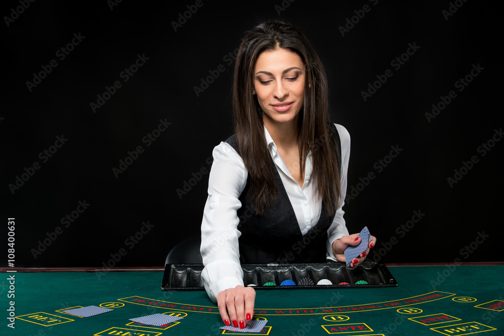 The beautiful girl, dealer, behind a table for poker The beautiful girl, dealer, behind a table for poker