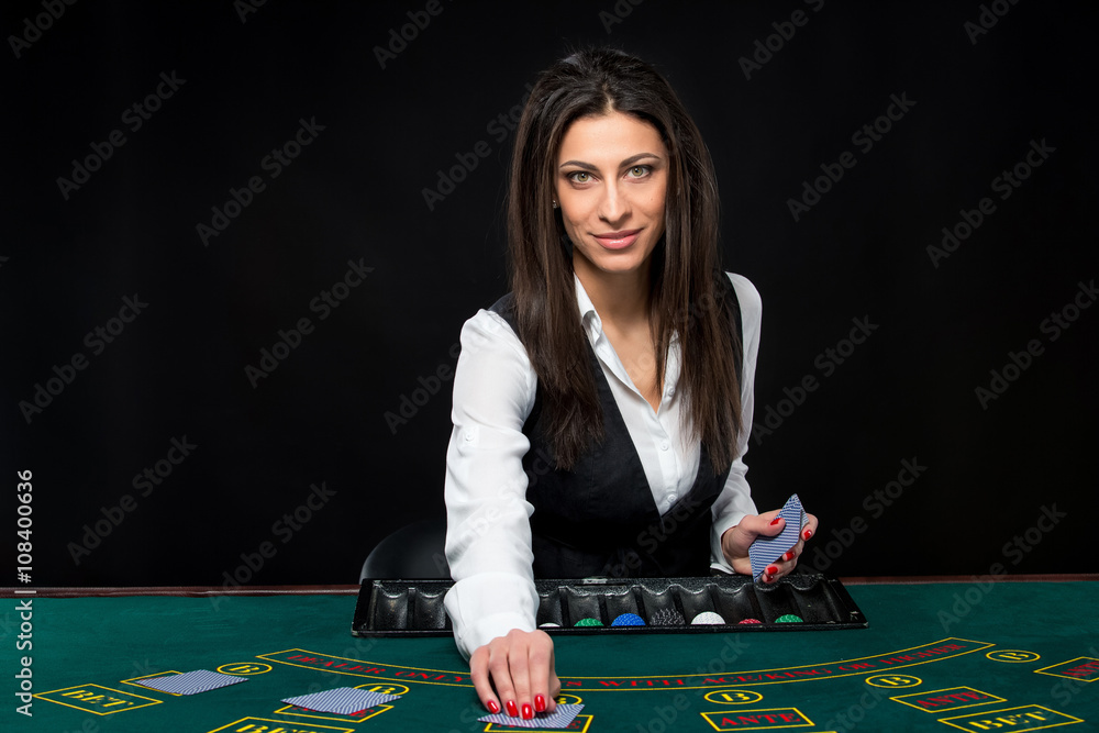 The beautiful girl, dealer, behind a table for poker The beautiful girl, dealer, behind a table for poker