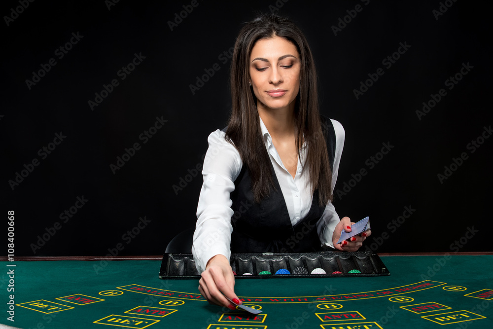 The beautiful girl, dealer, behind a table for poker The beautiful girl, dealer, behind a table for poker