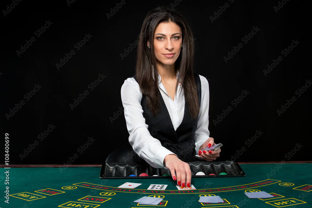 The beautiful girl, dealer, behind a table for poker The beautiful girl, dealer, behind a table for poker