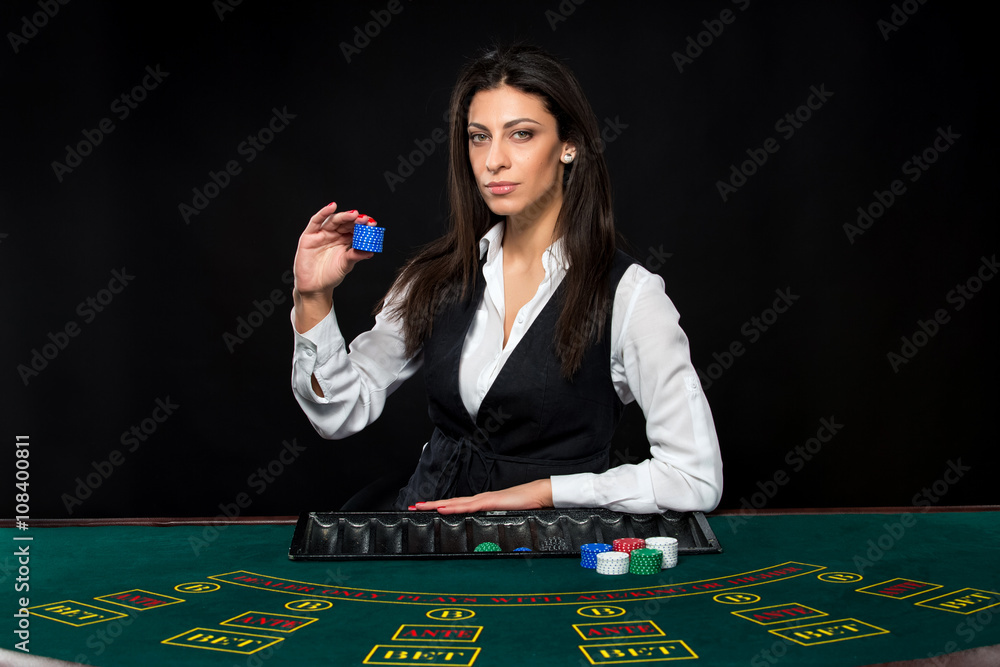 The beautiful girl, dealer, behind a table for poker The beautiful girl, dealer, behind a table for poker