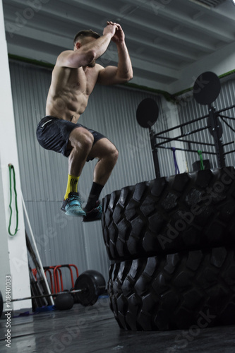 Bodybuilder doing box jumps at the gym