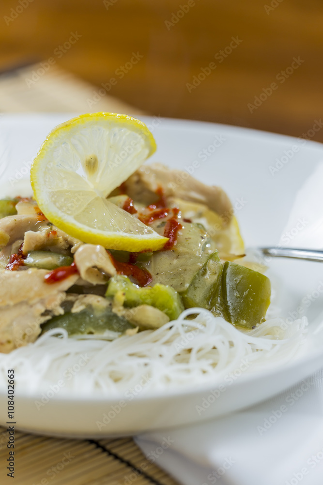 Closeup view of a bowl of thai green curry and rice vermicelli n
