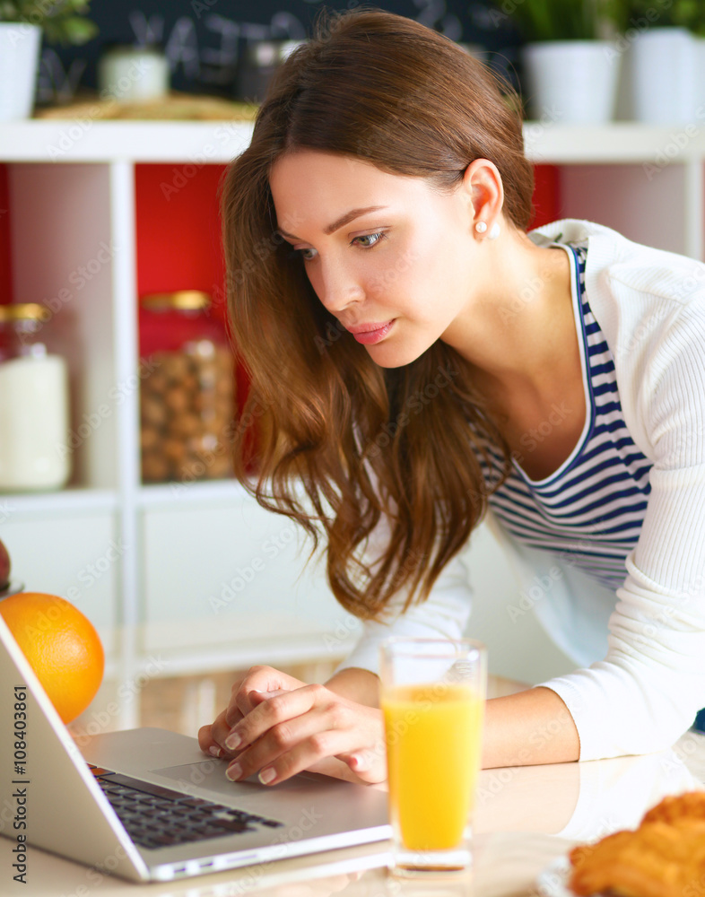 Young woman sitting near desk in the kitchen Young woman sitting near desk in the kitchen