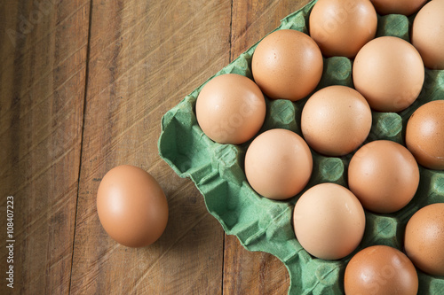 Fresh chicken eggs from the farm in a basket on a rustic wooden background