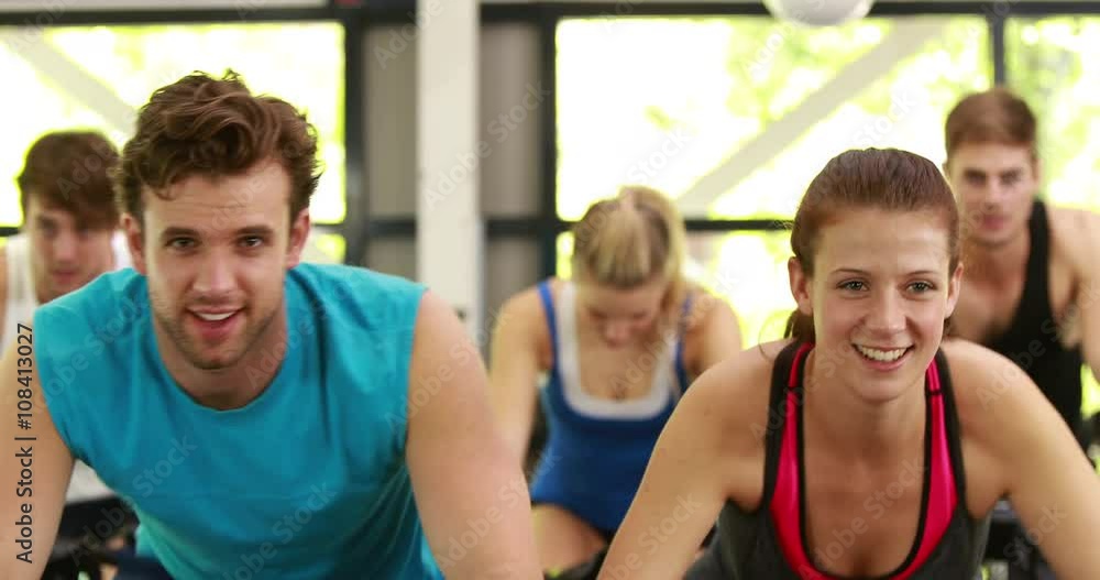 Fit group of people using exercise bike together Fit group of people using exercise bike together