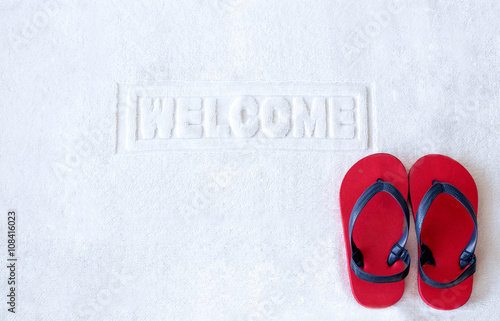 Welcome mat with red child sandals