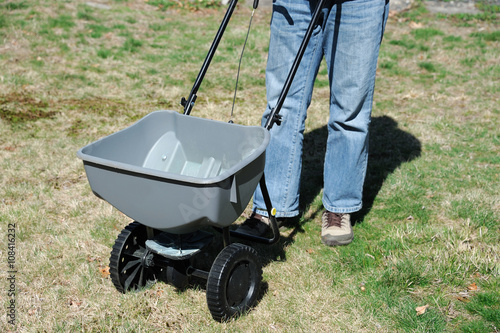 Φωτογραφία fertilizing the lawn by fertilizer spreader