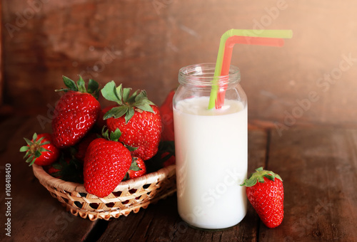 wooden table with strawberries and milk in a glass