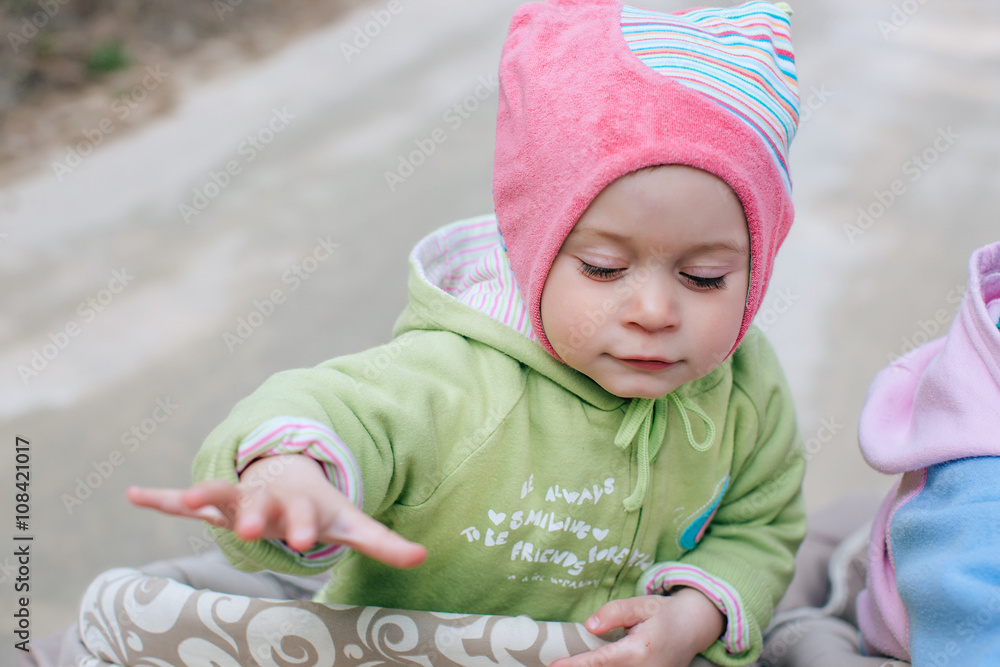 Funny girl baby in stroller in forest Funny girl baby in stroller in forest