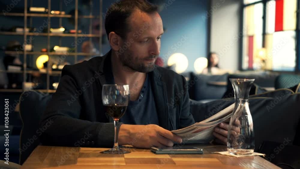 Young man reading magazine sitting in cafe
Young man reading magazine sitting in cafe