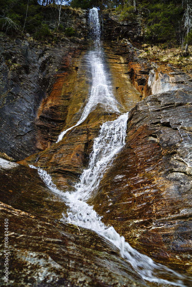 Landscape with a waterfall on colorful rocks Landscape with a waterfall on colorful rocks