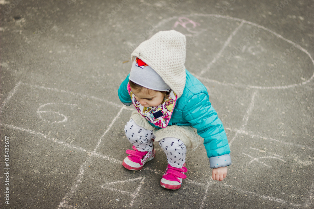 Naklejka premium Girl Playing Hopscotch on playground