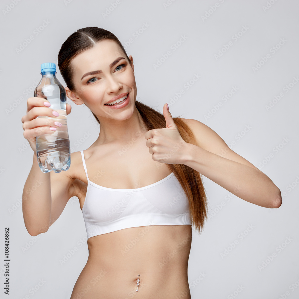sporty woman over gray background drinking water sporty woman over gray background drinking water