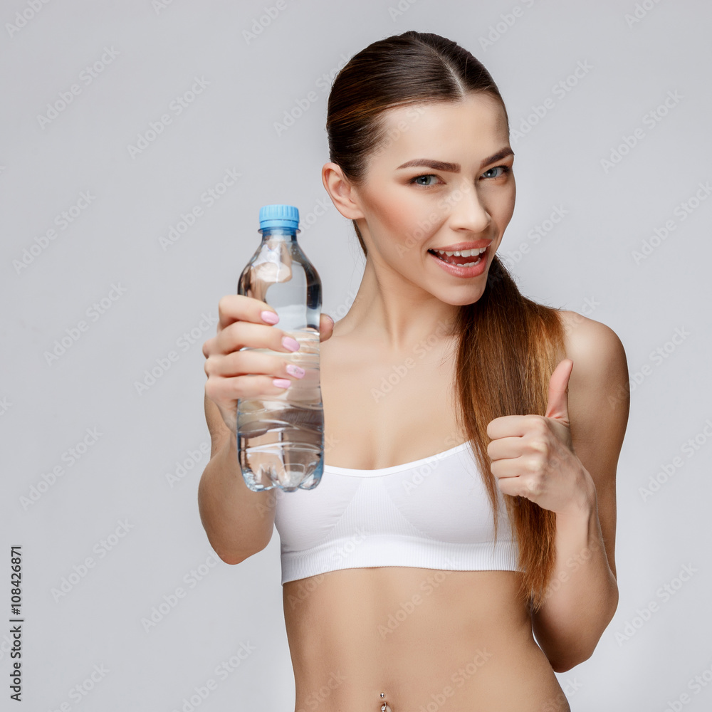 sporty woman over gray background drinking water sporty woman over gray background drinking water