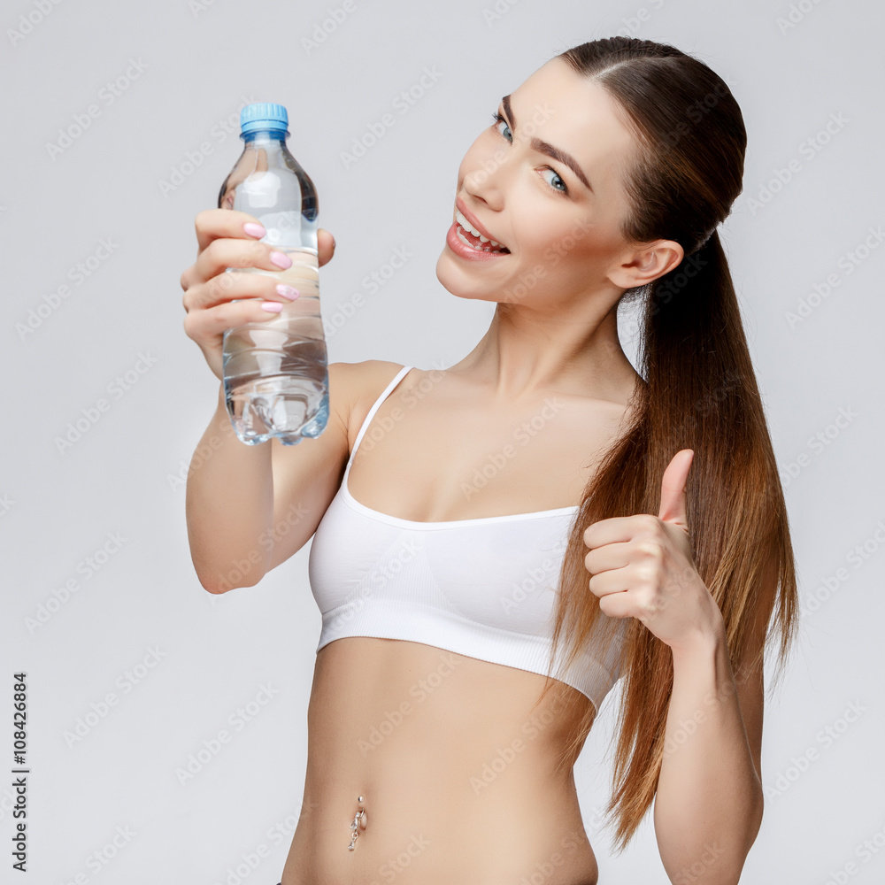 sporty woman over gray background drinking water sporty woman over gray background drinking water