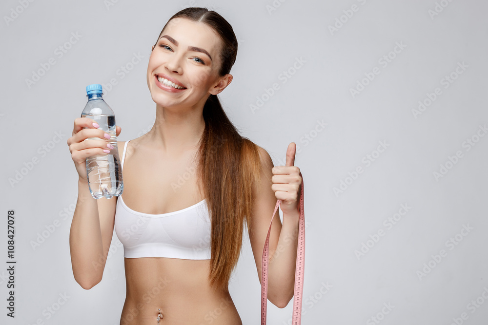 sporty woman over gray background drinking water sporty woman over gray background drinking water