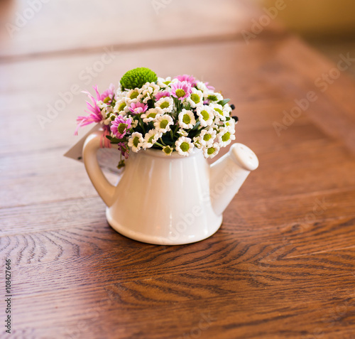 Close-up of artificial flowers in white watering