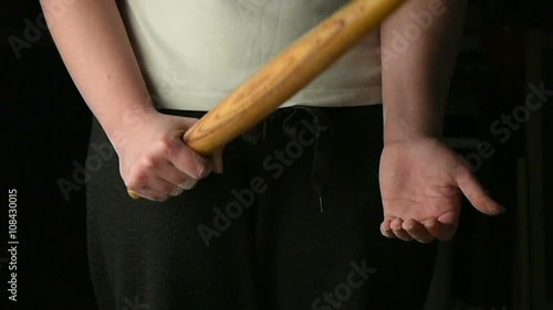 Female hands with a wooden stick
