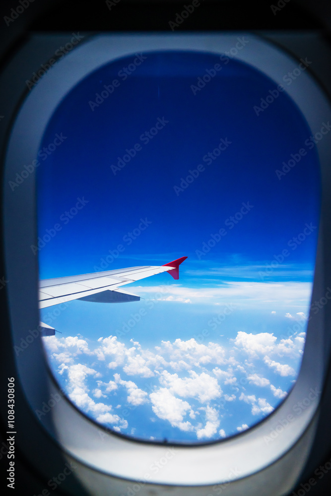 View from airplane window with blue sky and white clouds View from airplane window with blue sky and white clouds