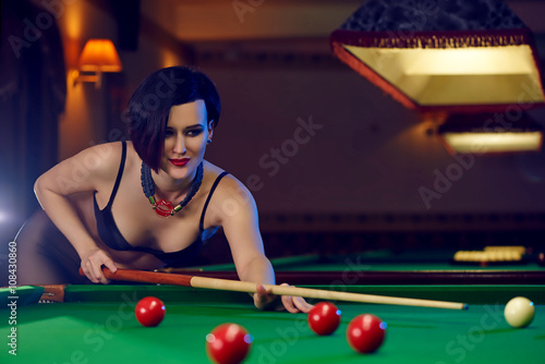 Hot sexy young woman at billiards club playing snooker