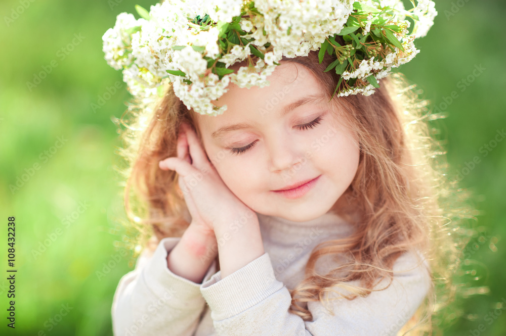 Cute baby girl 3-4 year old wearing flower wreath over green nature background. Posing outdoors. Childhood. Spring season. Cute baby girl 3-4 year old wearing flower wreath over green nature background. Posing outdoors. Childhood. Spring season.